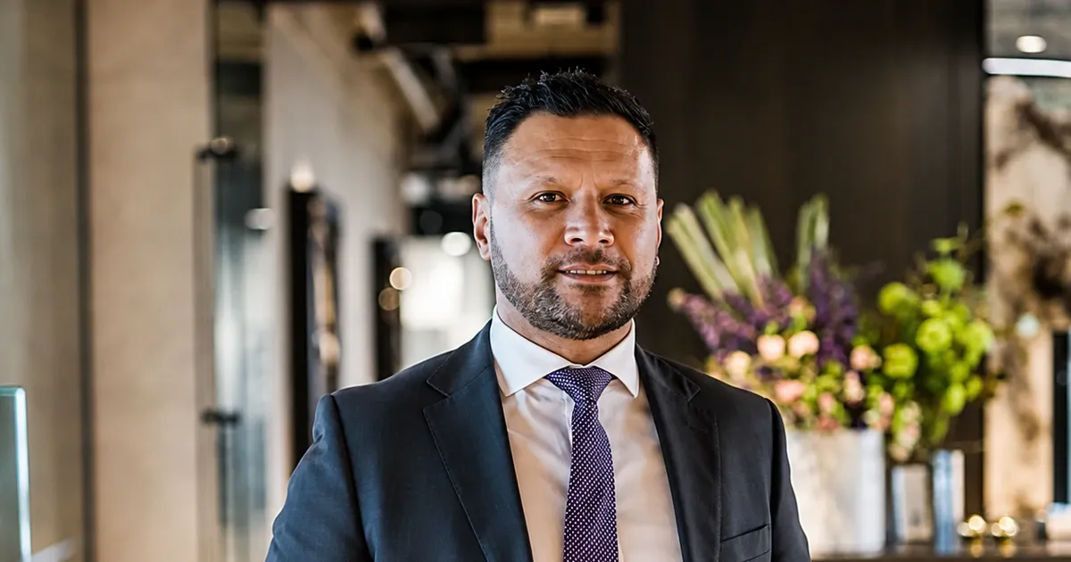 Mike Muriwai standing in a dealership showroom