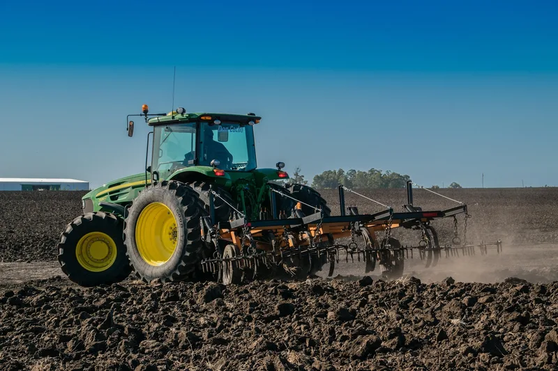 Tractor pulling cultivation equipment across a field