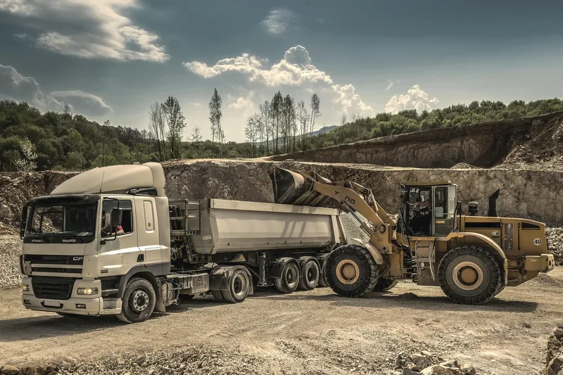 Tipper truck beside a wheel loader at a quarry
